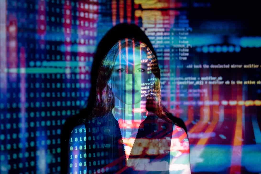 Woman standing in front of data code projection